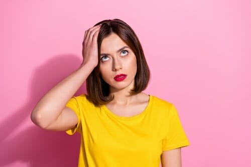 スペインで顔に手を当てた黄色いTシャツを着た若い女性。