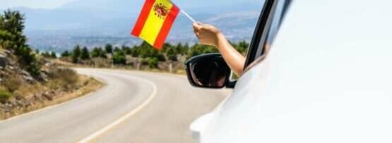 車の窓からスペイン国旗を振る人。