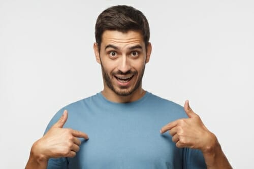 カメラに指を向ける男性。