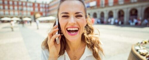 街中で電話で話す女性。