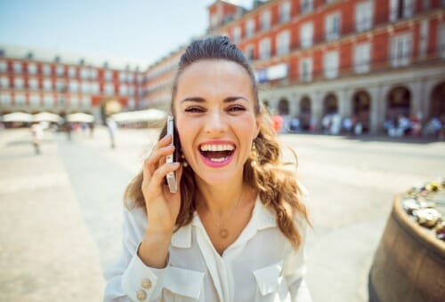 街中で電話で話す女性。