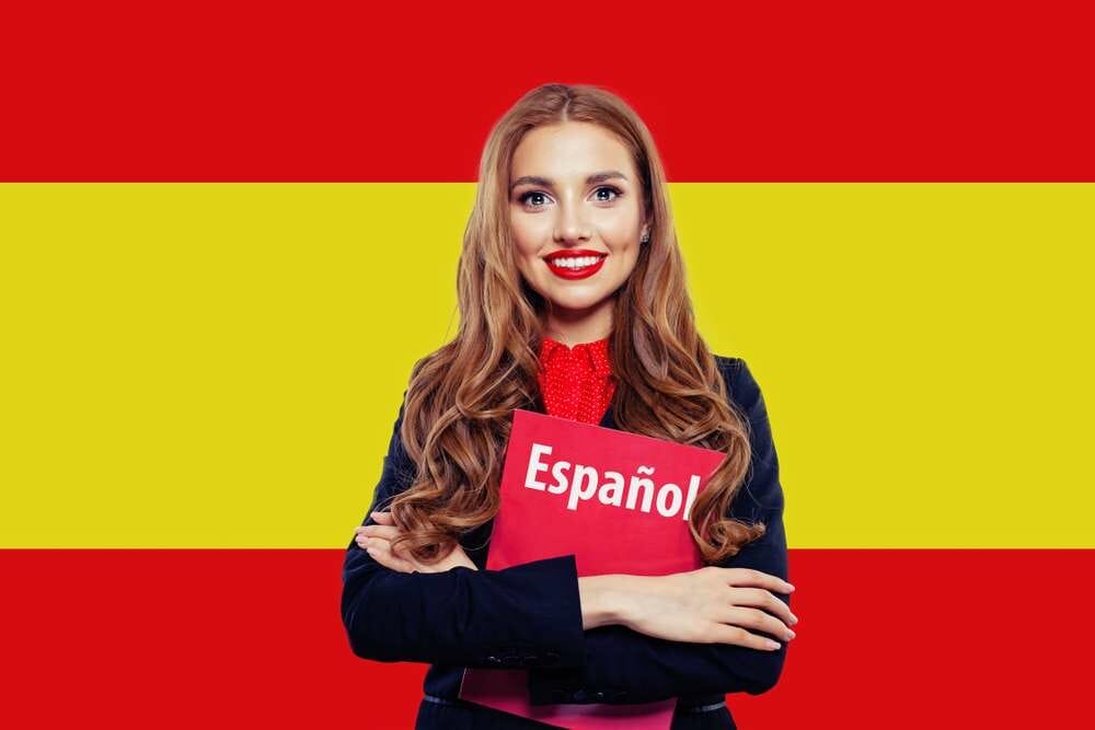 スペインの国旗の前でスペインの本を持っているスペインの女性。