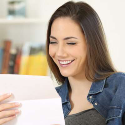 ソファに座りながらスペインからの手紙を読む女性。