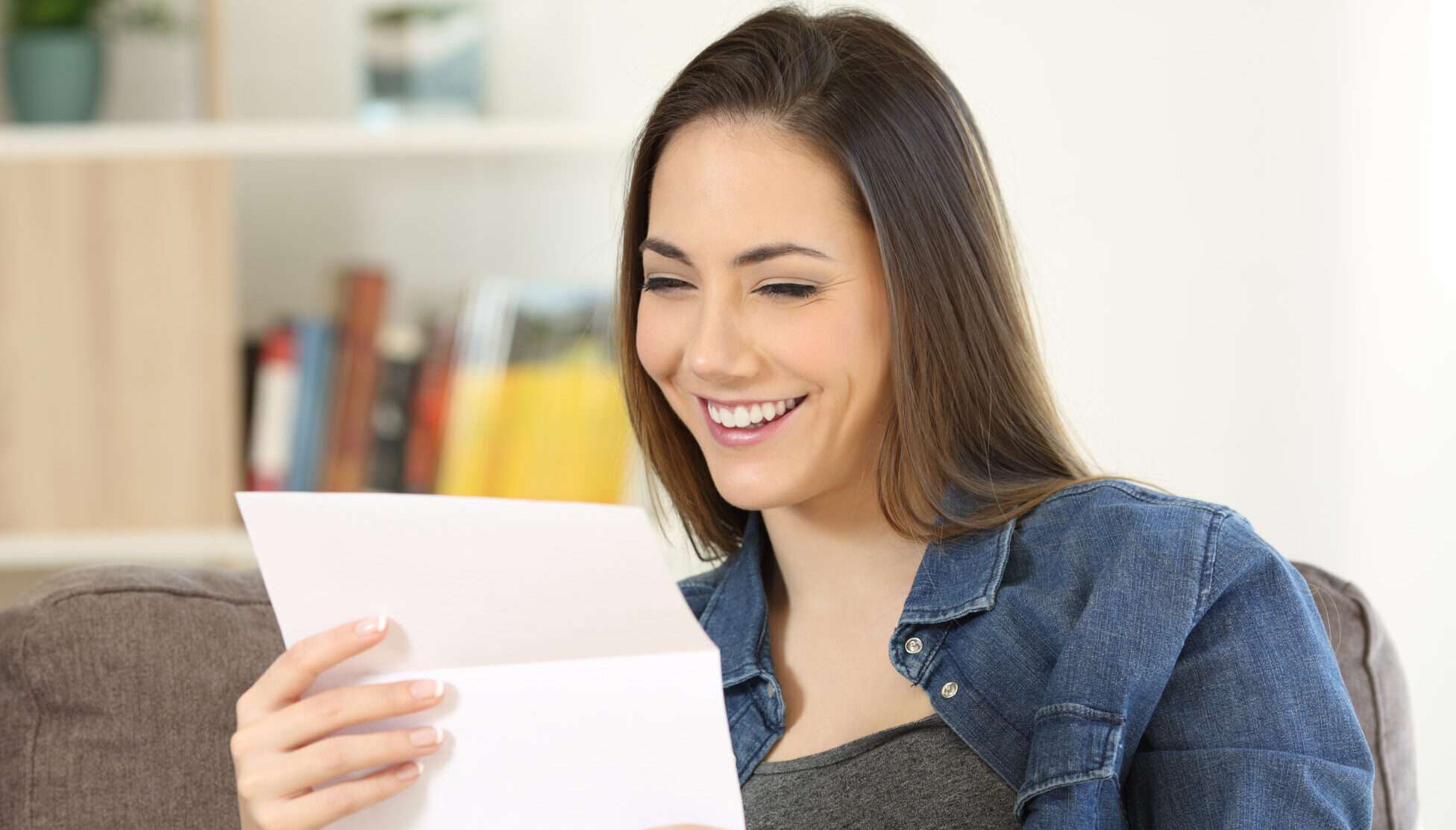 ソファに座りながらスペインからの手紙を読む女性。