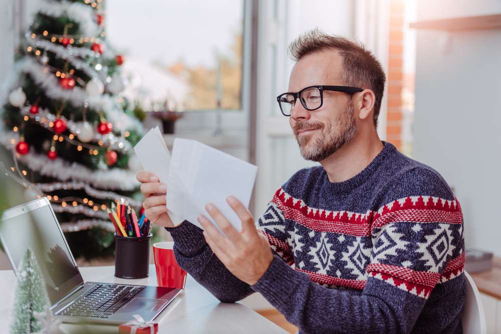 スペインの木の前で手紙を読む男性。