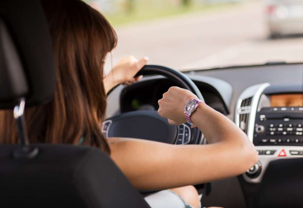 スペインで車を運転している女性がハンドルを握り、道路に集中し、車のダッシュボードとコントロールを詳しく見ています。