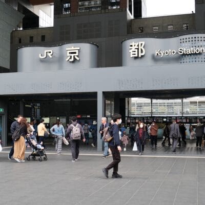 京都駅には人々が出入りしており、入口の上には「JR」と「京都駅」と書かれた看板が掲げられています。近くの居心地の良いカフェでは、京都の活気に満ちた雰囲気を楽しみながら学びたい人向けにマンツーマンスペイン語教室を開催しています。.