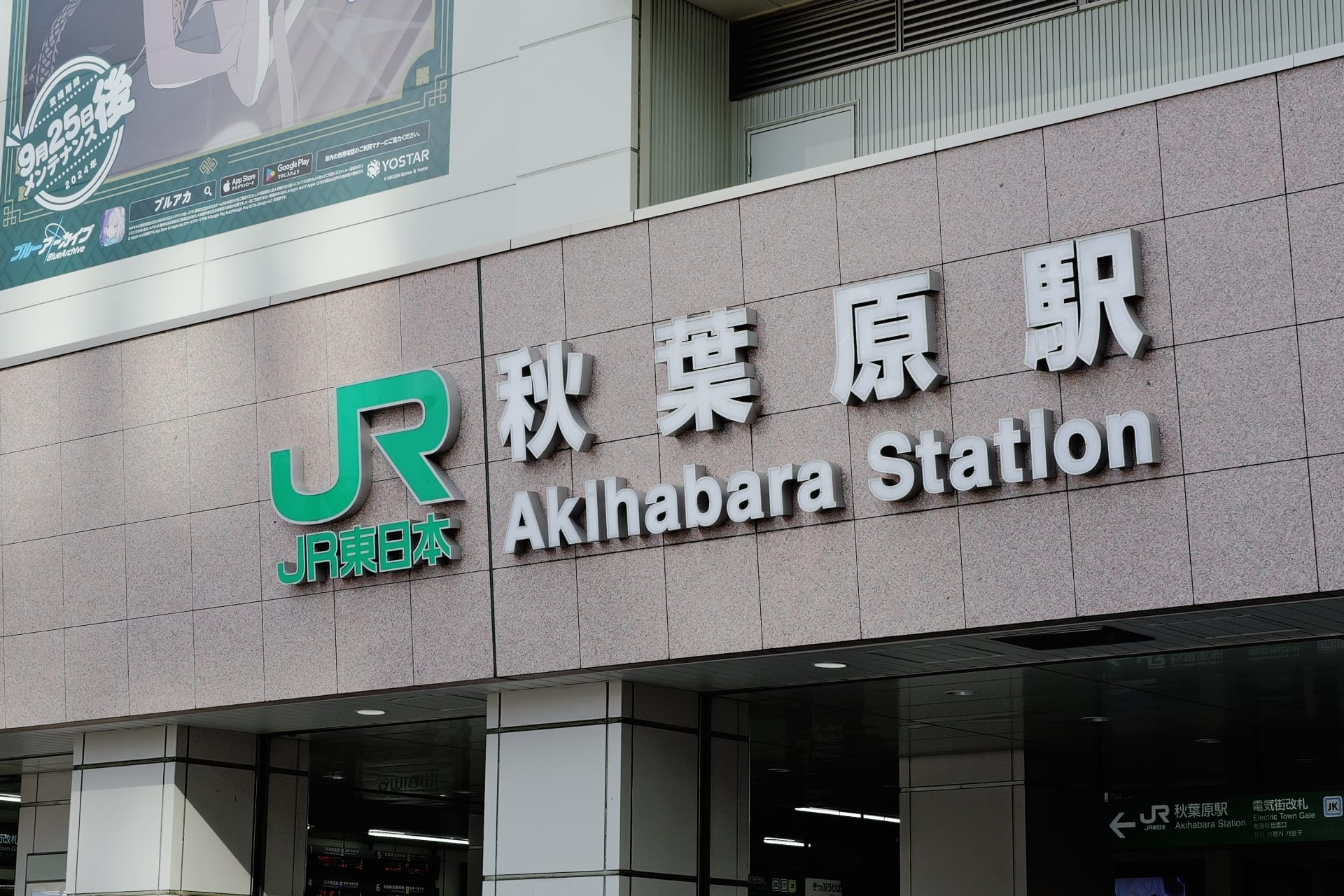 日本の秋葉原の中心部に位置する秋葉原駅の標識には、象徴的な JR のロゴが日本語と英語の両方のテキストで表示されています。.