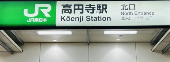 高円寺駅北口の標識。日本語、英語、韓国語の文字が書かれており、高円寺の活気ある多文化シーンを表現しています。.